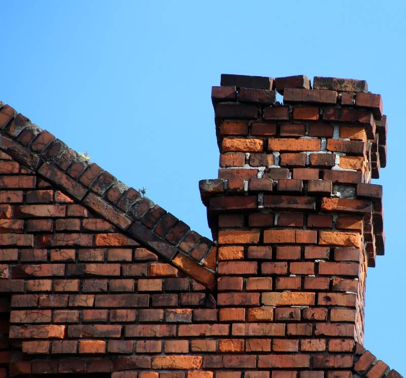 Damaged chimney on an Clawson home showing cracks and missing mortar